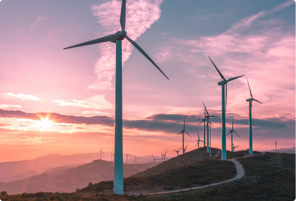 Pink sunrise over a valley populated with wind turbines