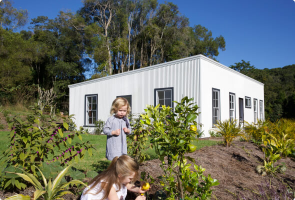 Two children picking lemons in a small allotment 